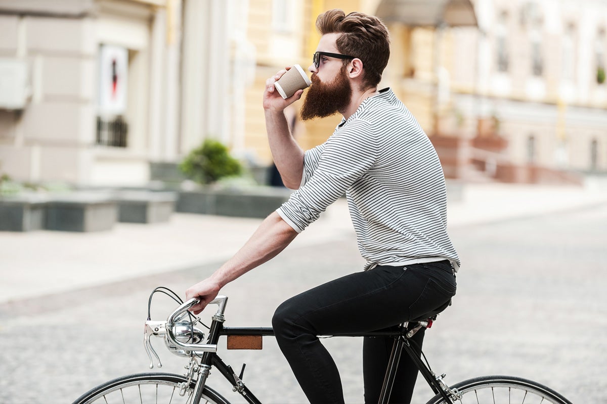 男人喝咖啡和骑自行车